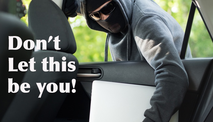 image of a thief breaking into a car and stealing the computer in the back seat